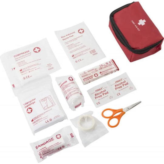 Compacte EHBO-set met pleisters, verband en schaar op witte achtergrond.